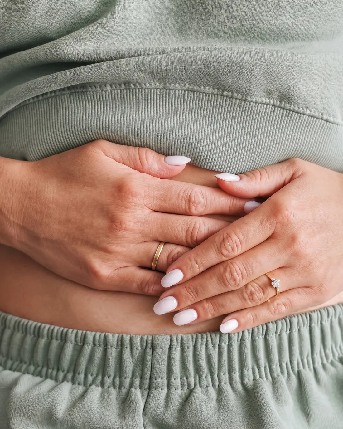 A woman resting both hands on her stomach