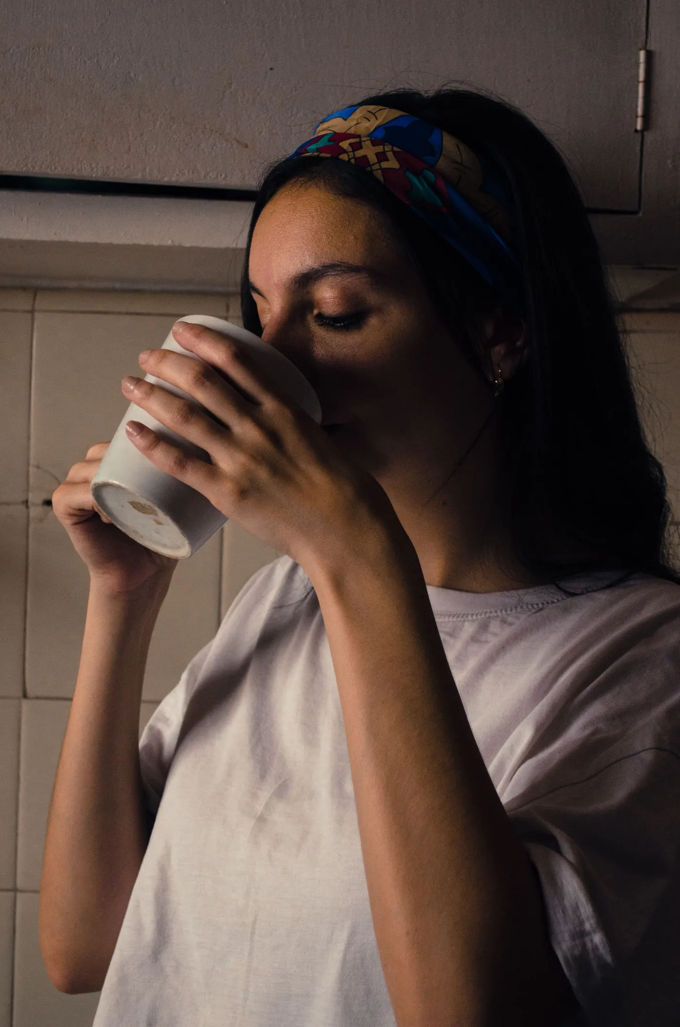 A woman drinking from a mug in the morning